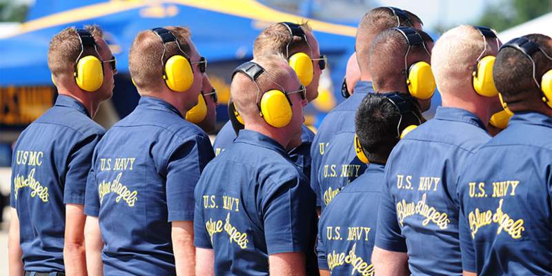 U.S. Navy Flight Demonstration Squadron, the Blue Angels, team members stand in formation as part of the ground demonstration prior to an aerial demonstration.